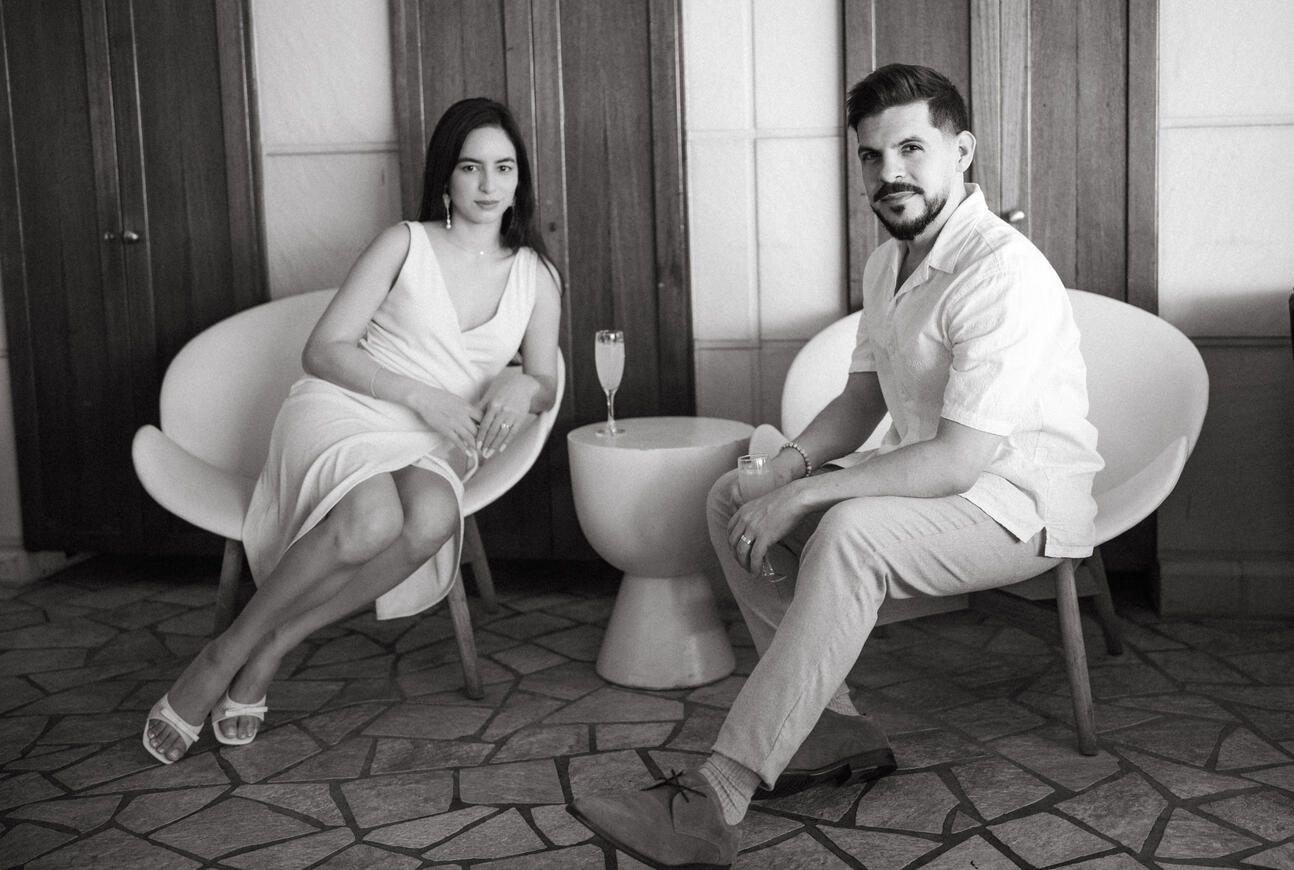 couple sitting down with mimosas for photoshoot