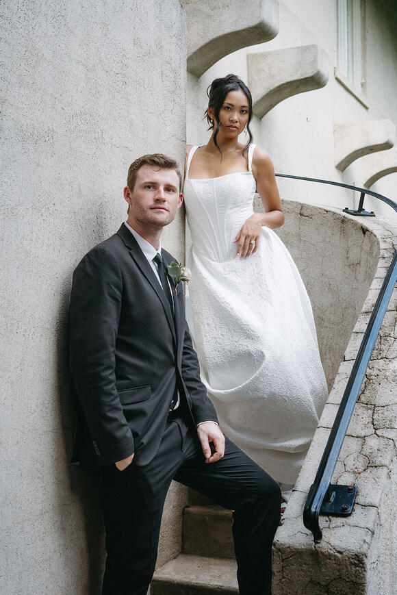couple posing on concrete spiral stairwell outside for editorial photoshoot during an elopement.